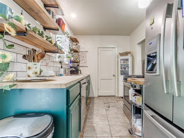 2133 SW 46th St, Oklahoma City, OK 73119 - kitchen featuring appliances with stainless steel finishes, open shelves, a sink, green cabinetry, and butcher block counters