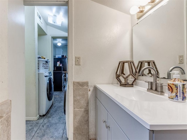 2133 SW 46th St, Oklahoma City, OK 73119 - bathroom featuring washer / dryer, vanity, and tile patterned floors