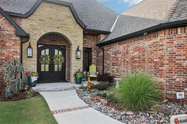 5813 Tiger Stone Dr, Mustang, OK 73064 - doorway to property with a shingled roof, brick siding, french doors, and stone siding