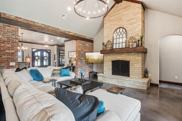 5813 Tiger Stone Dr, Mustang, OK 73064 - living room featuring a chandelier, a stone fireplace, high vaulted ceiling, concrete flooring, and baseboards