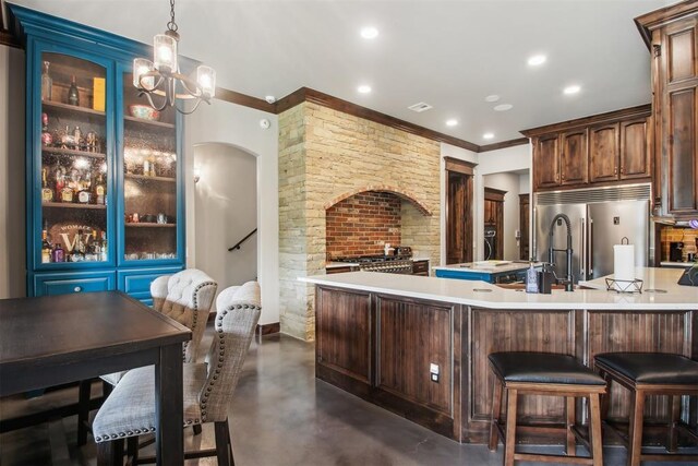 5813 Tiger Stone Dr, Mustang, OK 73064 - kitchen with high end fridge, finished concrete floors, light countertops, crown molding, and recessed lighting