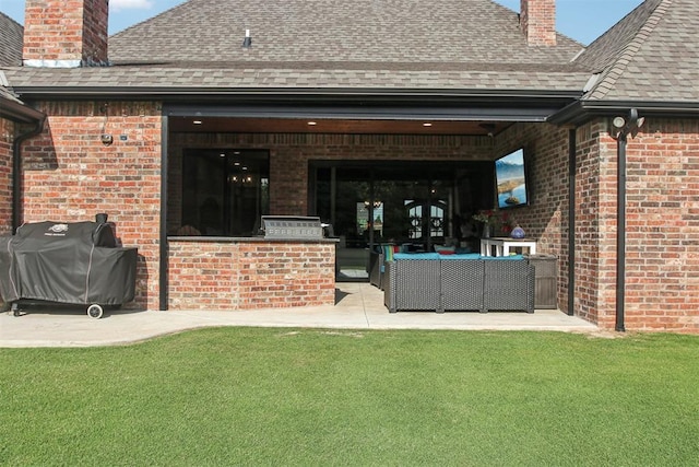 5813 Tiger Stone Dr, Mustang, OK 73064 - back of property with a chimney, brick siding, a shingled roof, an outdoor hangout area, and a patio