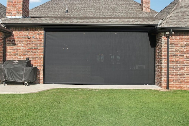 5813 Tiger Stone Dr, Mustang, OK 73064 - view of property exterior with a chimney, a shingled roof, brick siding, and a yard