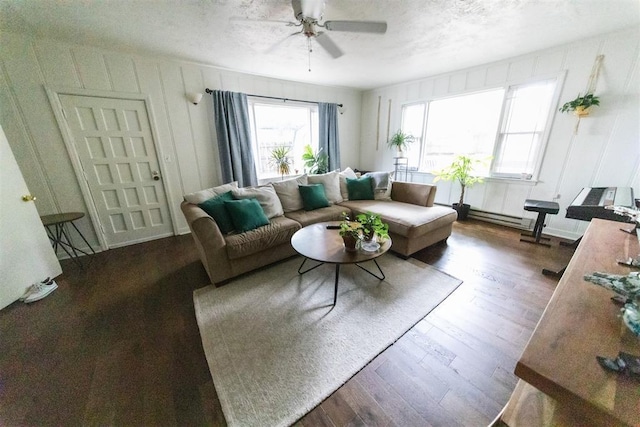 2616 NW 33rd St, Oklahoma City, OK 73112 - living room featuring ceiling fan, dark wood finished floors, baseboard heating, and a textured ceiling