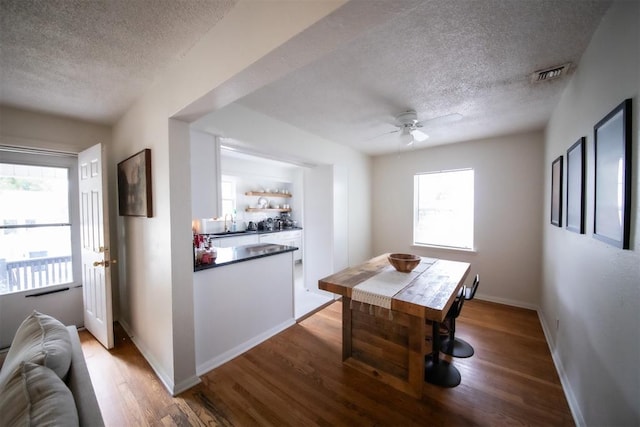 2616 NW 33rd St, Oklahoma City, OK 73112 - dining space featuring a textured ceiling, wood finished floors, ceiling fan, and baseboards
