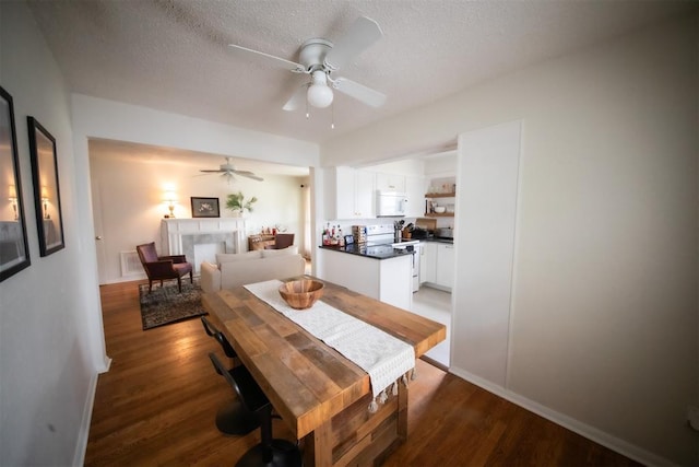 2616 NW 33rd St, Oklahoma City, OK 73112 - dining space with a ceiling fan, wood finished floors, a textured ceiling, and baseboards