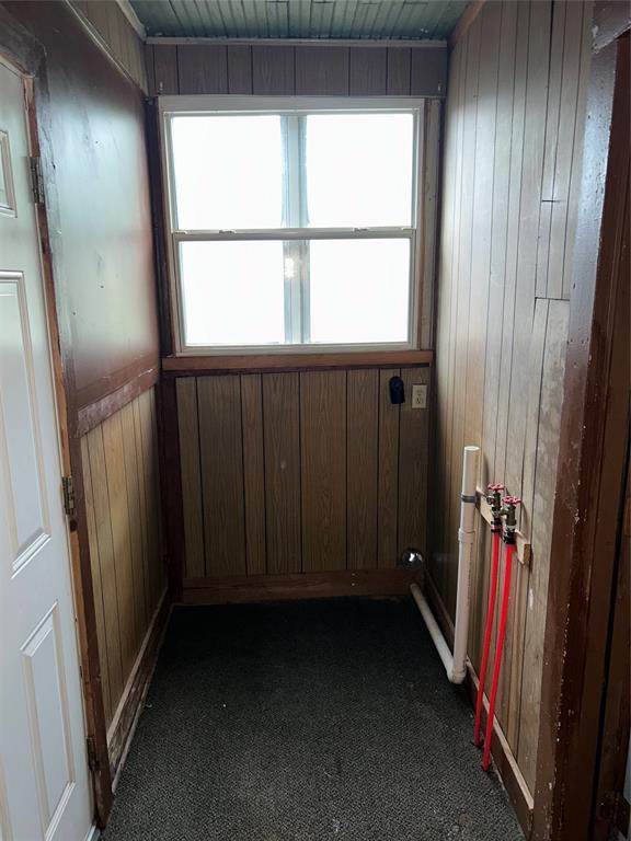 8312 Spencer Jones Rd, Jones, OK 73049 - empty room with wooden walls and dark colored carpet