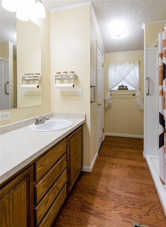 711 Sisson Ave, Sayre, OK 73662 - full bath featuring vanity, crown molding, wood finished floors, curtained shower, and a textured ceiling