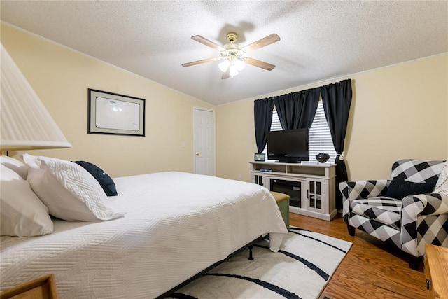 711 Sisson Ave, Sayre, OK 73662 - bedroom featuring wood finished floors, a textured ceiling, and ceiling fan