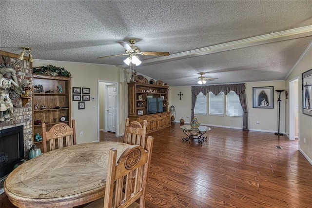 711 Sisson Ave, Sayre, OK 73662 - dining area featuring a ceiling fan, wood finished floors, lofted ceiling, a textured ceiling, and a brick fireplace