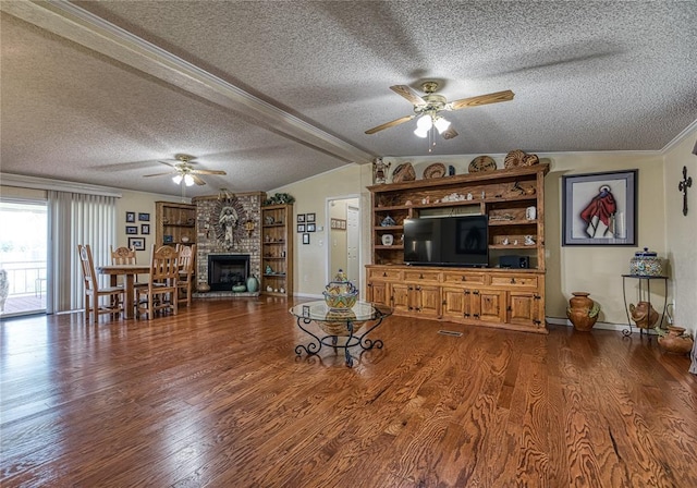 711 Sisson Ave, Sayre, OK 73662 - living room featuring a ceiling fan, a textured ceiling, wood finished floors, vaulted ceiling, and a fireplace