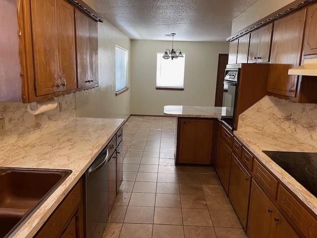 7716 S Charlotte Dr, Oklahoma City, OK 73159 - kitchen with black appliances, a peninsula, a textured ceiling, exhaust hood, and light countertops