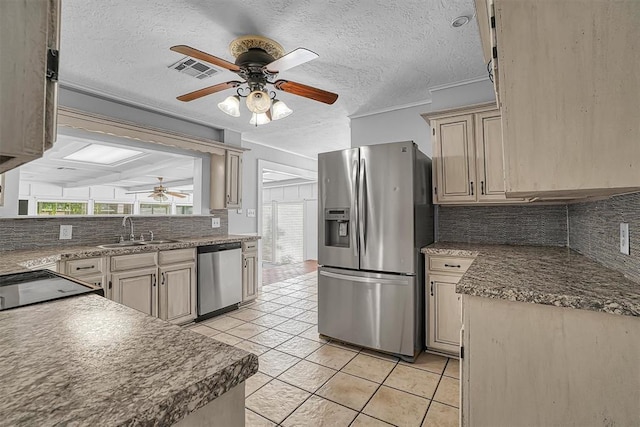 1016 E Cypress St, Altus, OK 73521 - kitchen featuring appliances with stainless steel finishes, ceiling fan, a sink, backsplash, and light tile patterned floors