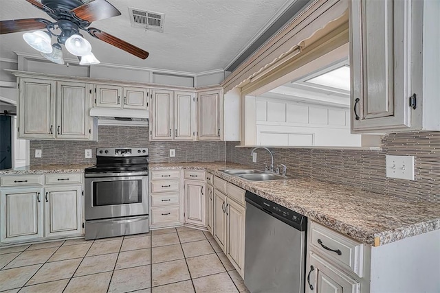 1016 E Cypress St, Altus, OK 73521 - kitchen featuring appliances with stainless steel finishes, a sink, under cabinet range hood, ceiling fan, and light tile patterned flooring
