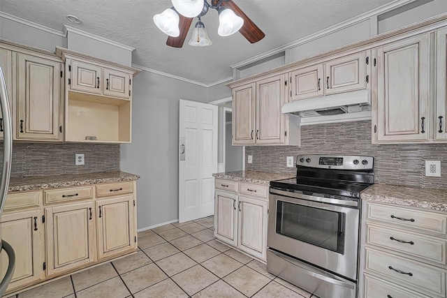 1016 E Cypress St, Altus, OK 73521 - kitchen with electric stove, under cabinet range hood, cream cabinets, light tile patterned flooring, and tasteful backsplash