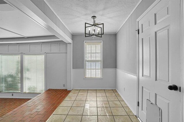 1016 E Cypress St, Altus, OK 73521 - unfurnished dining area featuring a chandelier, crown molding, and a textured ceiling