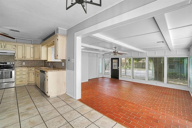 1016 E Cypress St, Altus, OK 73521 - kitchen with a ceiling fan, appliances with stainless steel finishes, under cabinet range hood, backsplash, and beamed ceiling