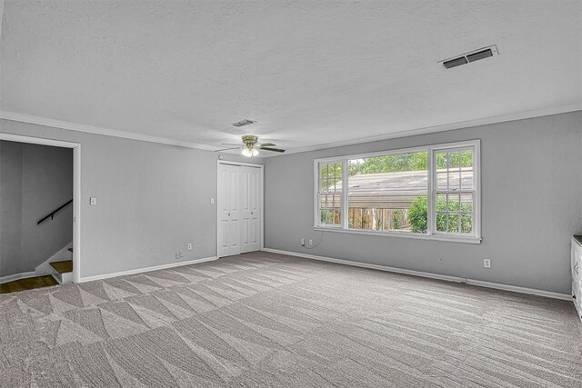 1016 E Cypress St, Altus, OK 73521 - carpeted spare room with a textured ceiling, crown molding, a ceiling fan, stairway, and baseboards