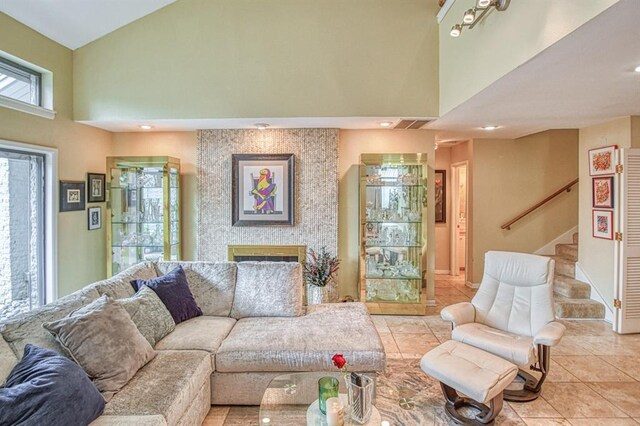 3605 Hampton Ct, Norman, OK 73072 - living area with a large fireplace, a towering ceiling, stairs, light tile patterned floors, and recessed lighting