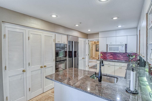 3605 Hampton Ct, Norman, OK 73072 - kitchen with a sink, stainless steel appliances, white cabinets, a peninsula, and recessed lighting