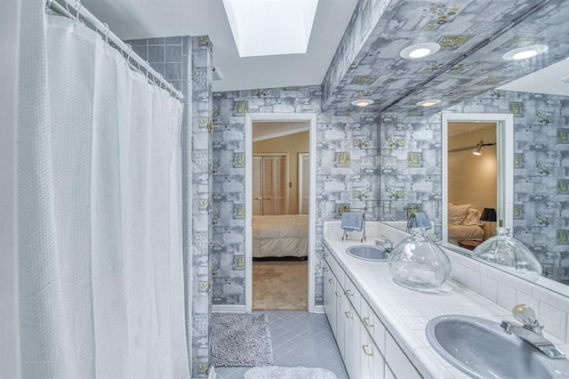 3605 Hampton Ct, Norman, OK 73072 - bathroom with connected bathroom, wallpapered walls, double vanity, tile patterned floors, and a skylight