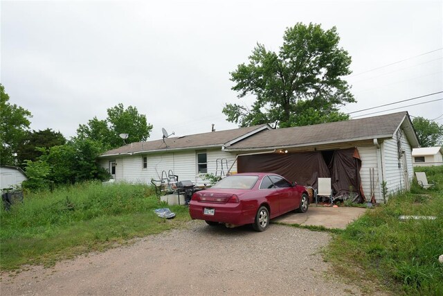 single story home featuring dirt driveway and an attached garage