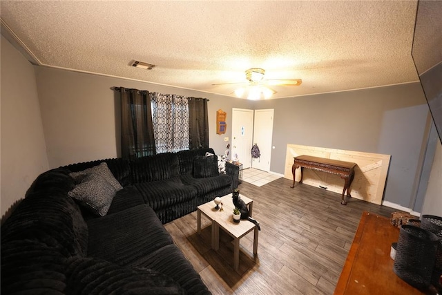 living area featuring wood finished floors, a textured ceiling, and a ceiling fan