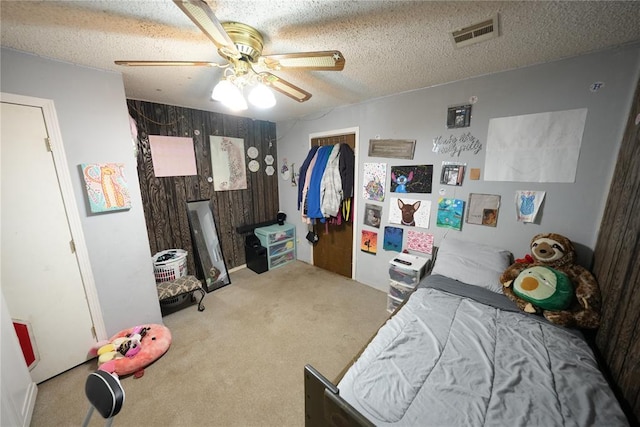 bedroom with carpet, ceiling fan, and a textured ceiling