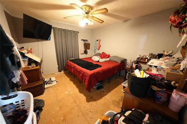 bedroom with ceiling fan and a textured ceiling
