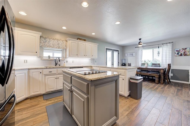 13131 SW 15th St, Yukon, OK 73099 - kitchen with a sink, freestanding refrigerator, a peninsula, a kitchen island, and light wood finished floors