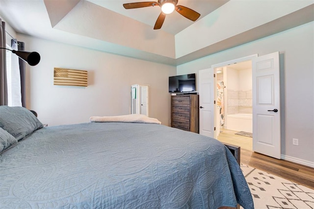 13131 SW 15th St, Yukon, OK 73099 - bedroom with wood finished floors, ensuite bathroom, a ceiling fan, and baseboards