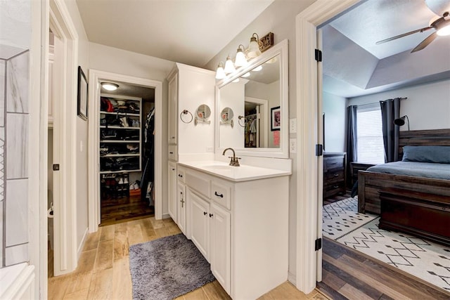 13131 SW 15th St, Yukon, OK 73099 - bathroom with vanity, ceiling fan, wood finished floors, and a walk in closet