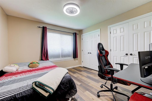 13131 SW 15th St, Yukon, OK 73099 - bedroom featuring wood finished floors, two closets, baseboards, and an office area