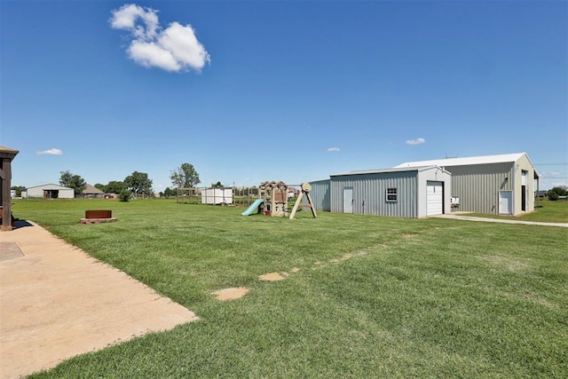 13131 SW 15th St, Yukon, OK 73099 - view of grassy yard featuring a playground, a garage, and an outdoor structure