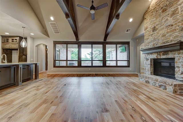 1440 Station St, Edmond, OK 73034 - unfurnished living room featuring arched walkways, high vaulted ceiling, baseboards, ceiling fan, and beamed ceiling