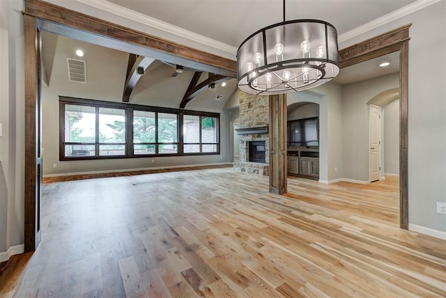 1440 Station St, Edmond, OK 73034 - unfurnished living room featuring baseboards, crown molding, arched walkways, light wood-type flooring, and a chandelier