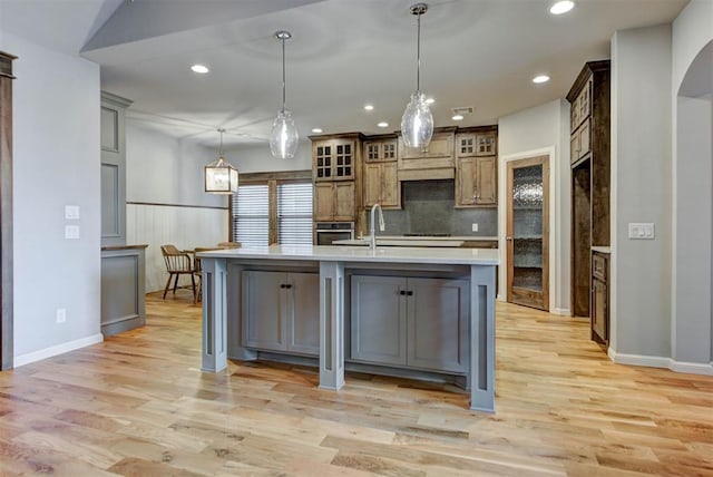 1440 Station St, Edmond, OK 73034 - kitchen featuring stainless steel oven, light countertops, recessed lighting, light wood finished floors, and decorative backsplash