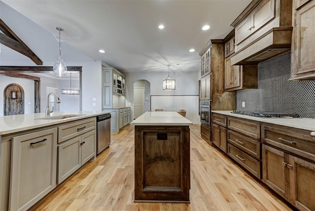 1440 Station St, Edmond, OK 73034 - kitchen featuring a sink, stainless steel appliances, a center island, a wainscoted wall, and glass insert cabinets