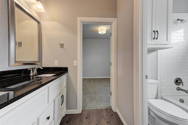 1440 Station St, Edmond, OK 73034 - bathroom featuring vanity, toilet, washtub / shower combination, wood finished floors, and baseboards