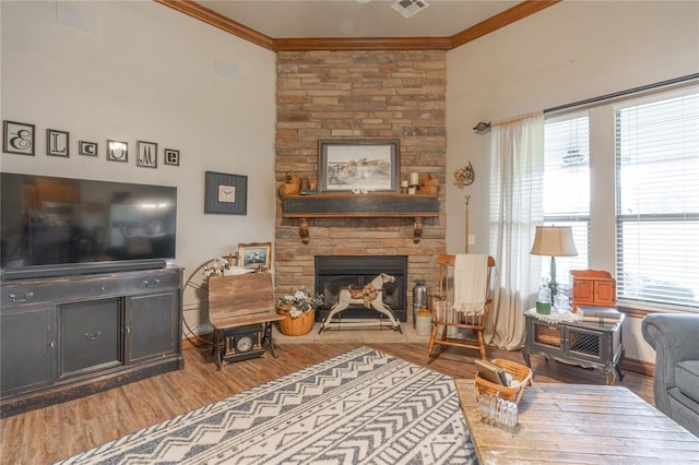 13605 Verona Strada, Oklahoma City, OK 73170 - living room featuring ornamental molding, wood finished floors, a stone fireplace, and baseboards