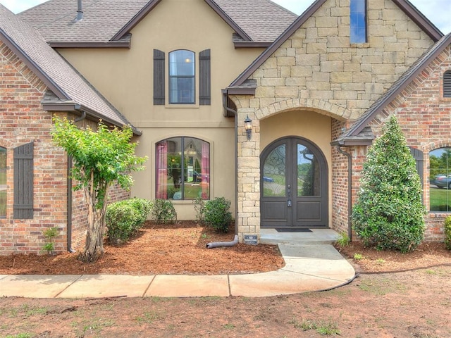 15228 Turtle Lake Pl, Oklahoma City, OK 73165 - property entrance featuring french doors, stucco siding, roof with shingles, and brick siding