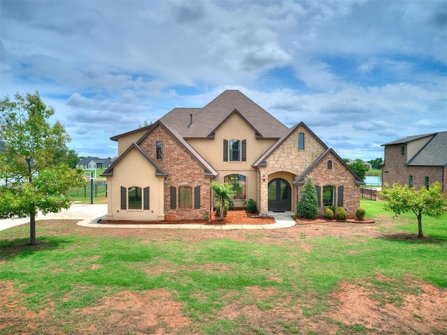 15228 Turtle Lake Pl, Oklahoma City, OK 73165 - french country inspired facade with stucco siding, stone siding, a front lawn, and roof with shingles