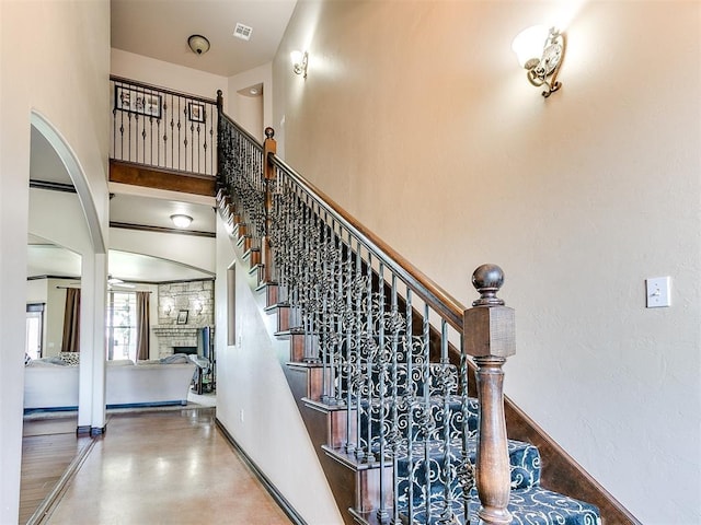 15228 Turtle Lake Pl, Oklahoma City, OK 73165 - stairs with a stone fireplace, baseboards, and a towering ceiling