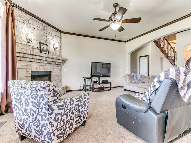 15228 Turtle Lake Pl, Oklahoma City, OK 73165 - carpeted living area with crown molding, a fireplace, baseboards, a ceiling fan, and arched walkways