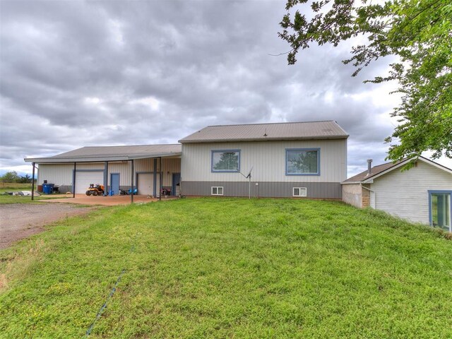 4355 S Midwest Blvd, Guthrie, OK 73044 - rear view of house featuring driveway, a lawn, and metal roof