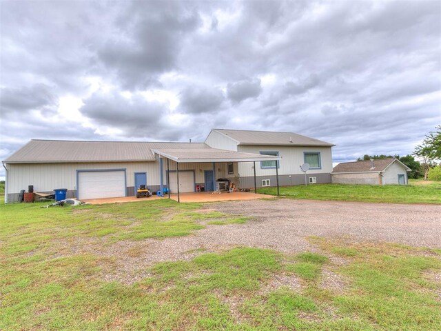 4355 S Midwest Blvd, Guthrie, OK 73044 - back of house featuring dirt driveway, a lawn, and an outdoor structure