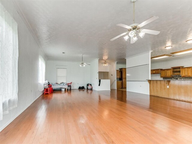 4355 S Midwest Blvd, Guthrie, OK 73044 - unfurnished living room featuring a ceiling fan, hardwood / wood-style floors, and ornamental molding