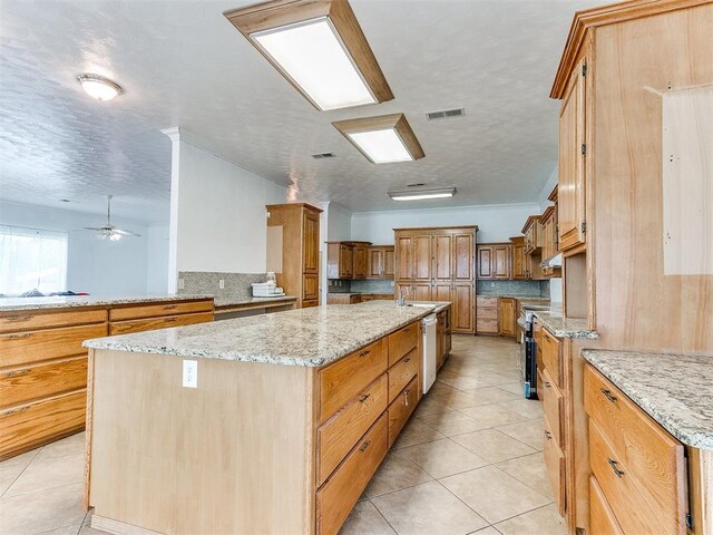 4355 S Midwest Blvd, Guthrie, OK 73044 - kitchen featuring a kitchen island, electric range, light tile patterned floors, light stone counters, and a textured ceiling