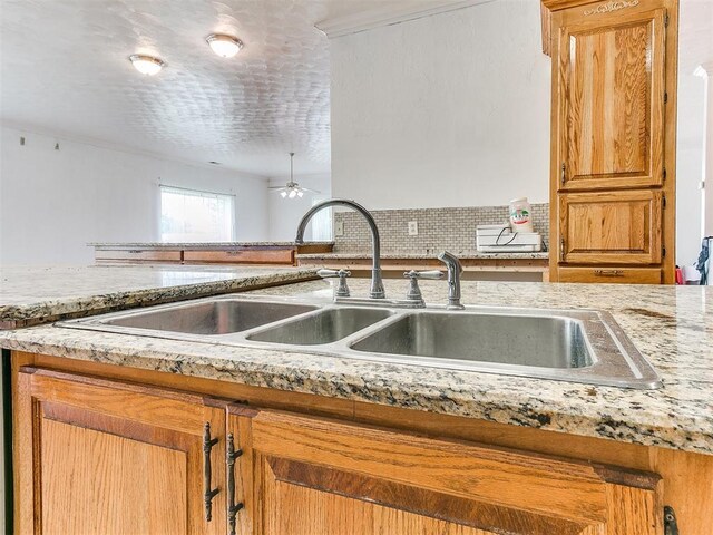 4355 S Midwest Blvd, Guthrie, OK 73044 - kitchen featuring a sink, ceiling fan, and brown cabinets
