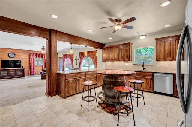 2801 John Deere Ave Unit 1, Edmond, OK 73034 - kitchen with appliances with stainless steel finishes, ceiling fan, recessed lighting, brown cabinets, and decorative backsplash